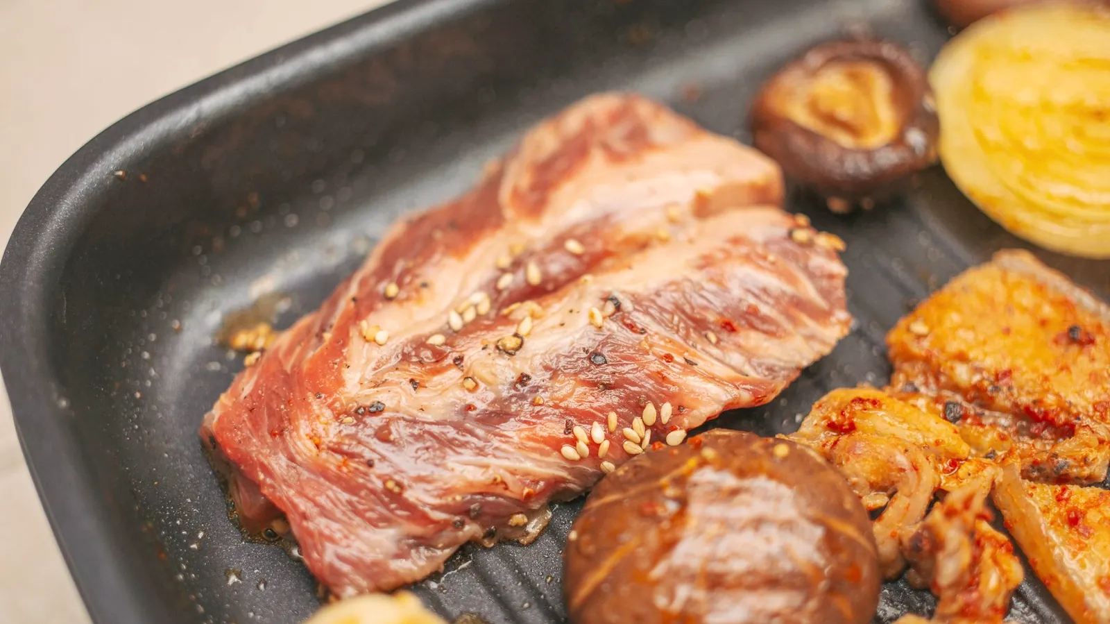 紀州備長炭の上で肉と野菜を焼くようす