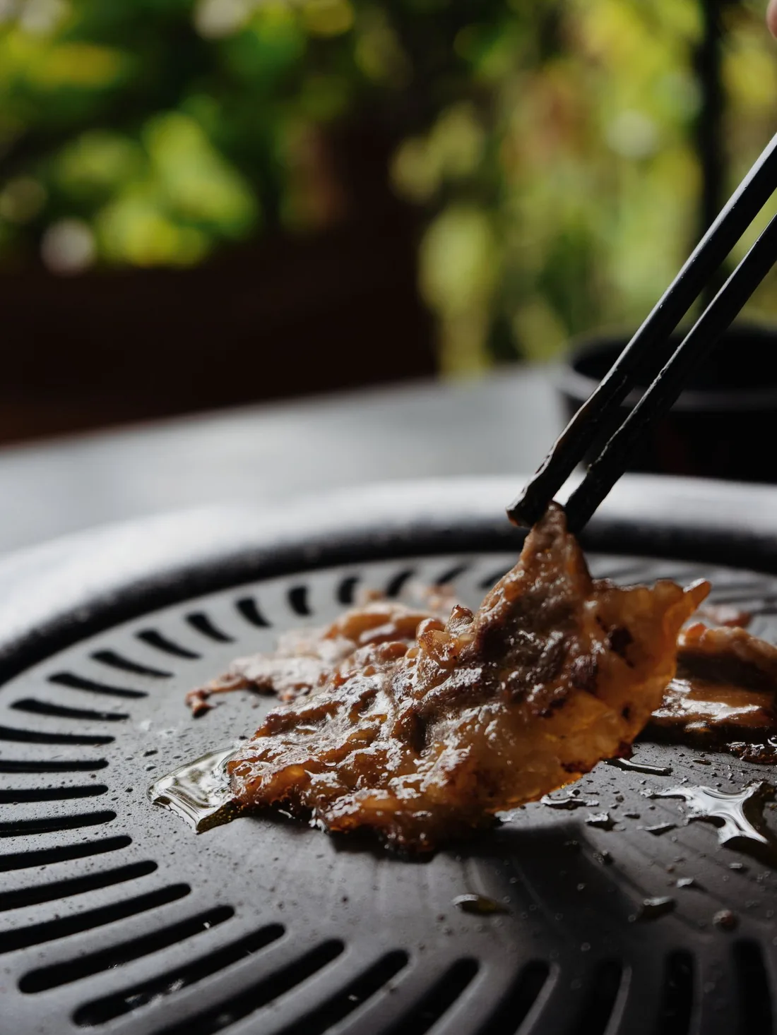 部位に合わせて厚みを変えて切った肉を網で焼くようす